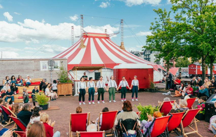 Die Tänzer*innen von tanzbar_bremen stehen vor dem applaudierenden Publikum auf dem Circusplatz des Fantasia